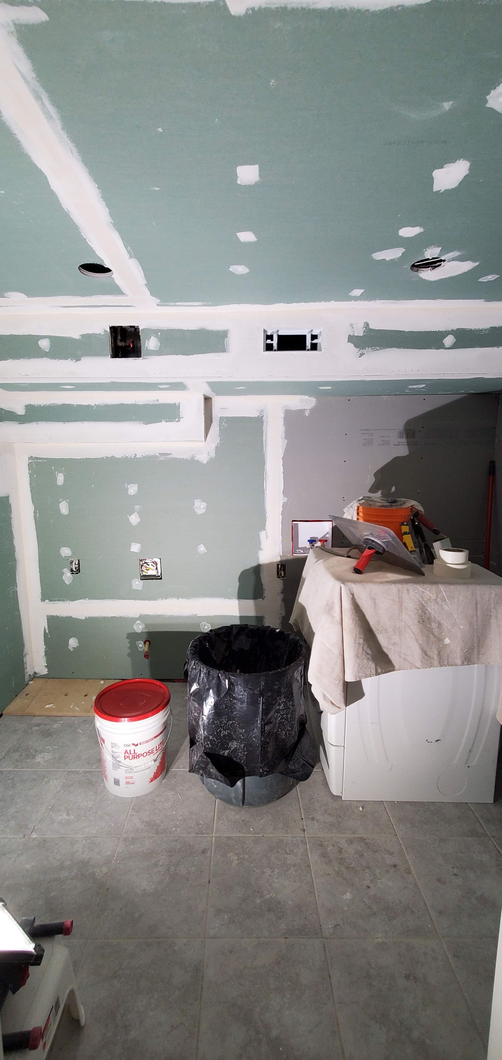 A room with a table and buckets of paint on the floor.