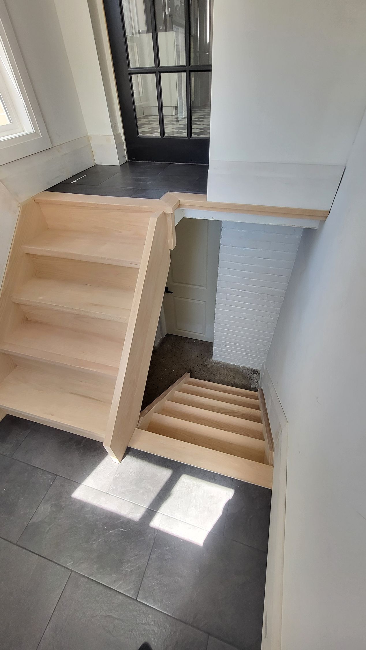 Wooden staircase leading down with natural light.