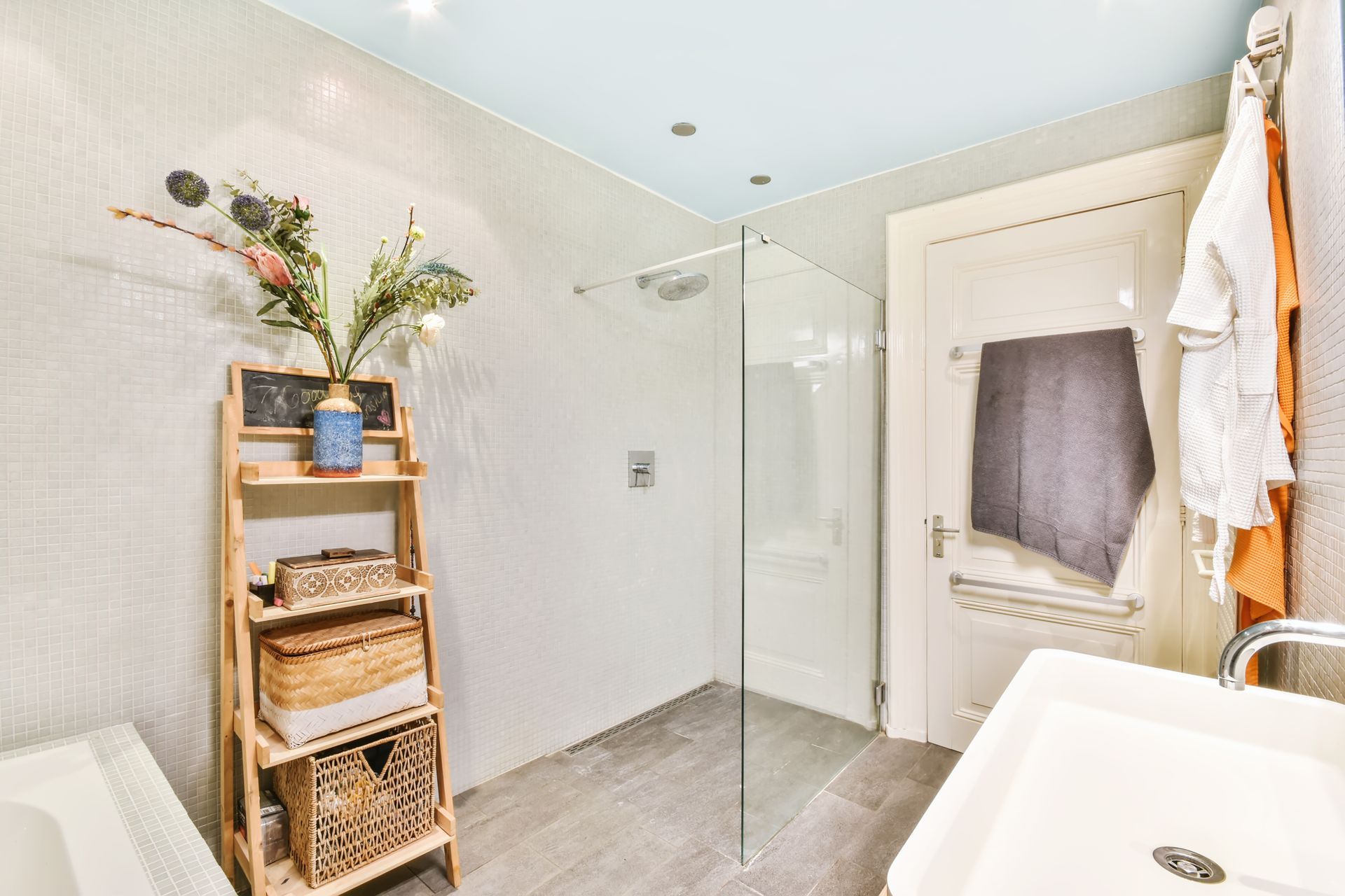 A bathroom with a walk in shower and a sink.