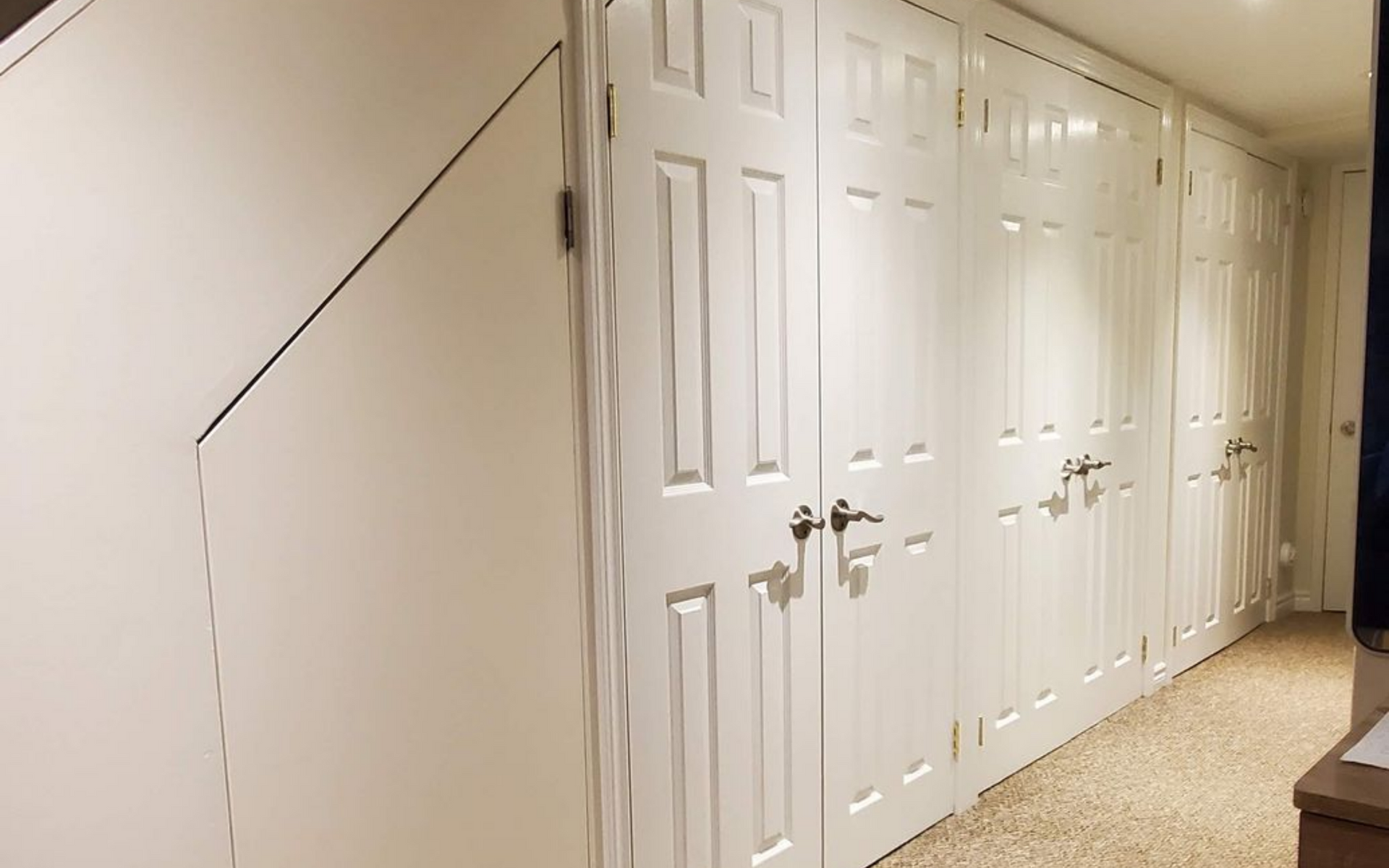 White closet doors line a wall. A staircase is visible on the left.