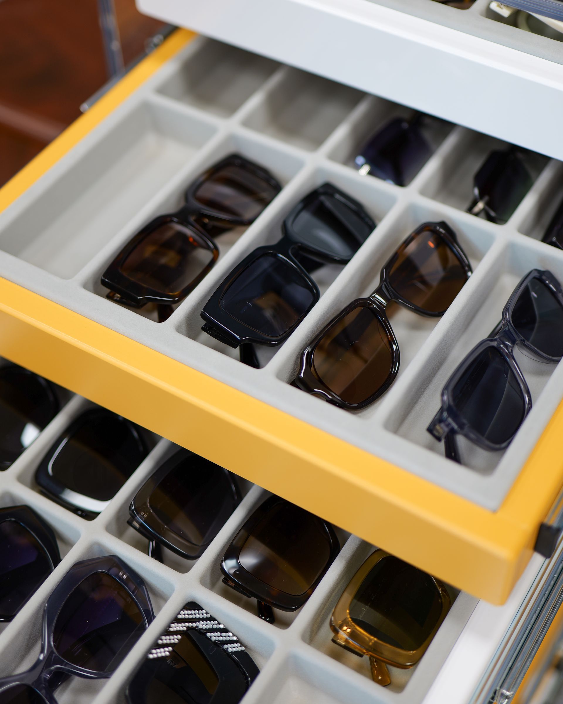 Cassetto giallo con occhiali da sole organizzati in scomparti.