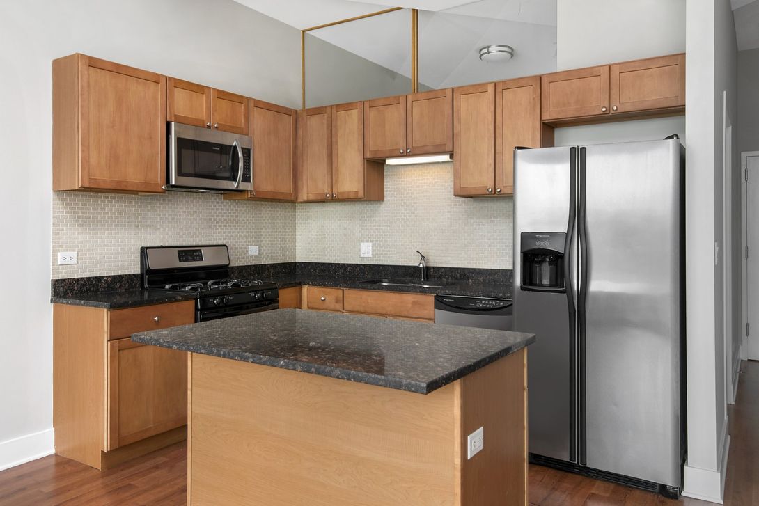 Kitchen with island and stainless steel appliances at 2000 N Milwaukee Apartments.
