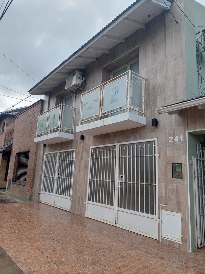 Casa de dos plantas con balcones, puertas blancas y fachada de azulejos. Dirección: 241.