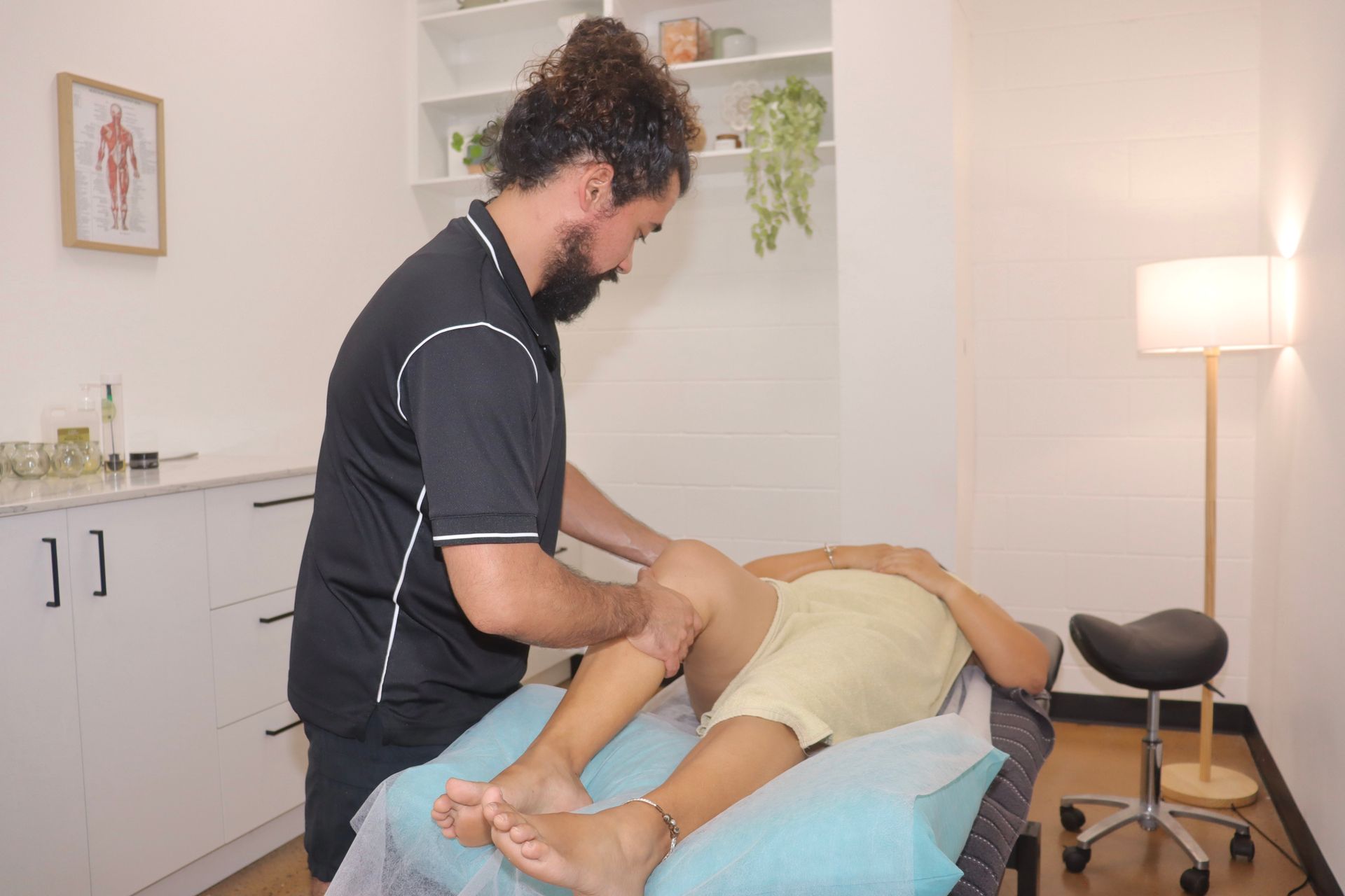 A Man In A Black Shirt Is Giving A Man A Nice Massage — Inner Balance Health in Darwin