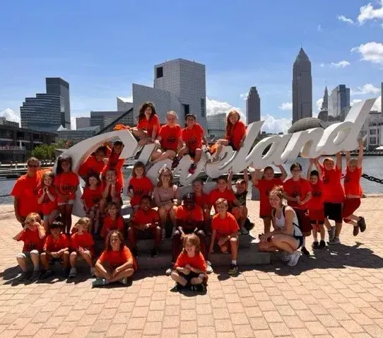 A group of people posing in front of a cleveland sign