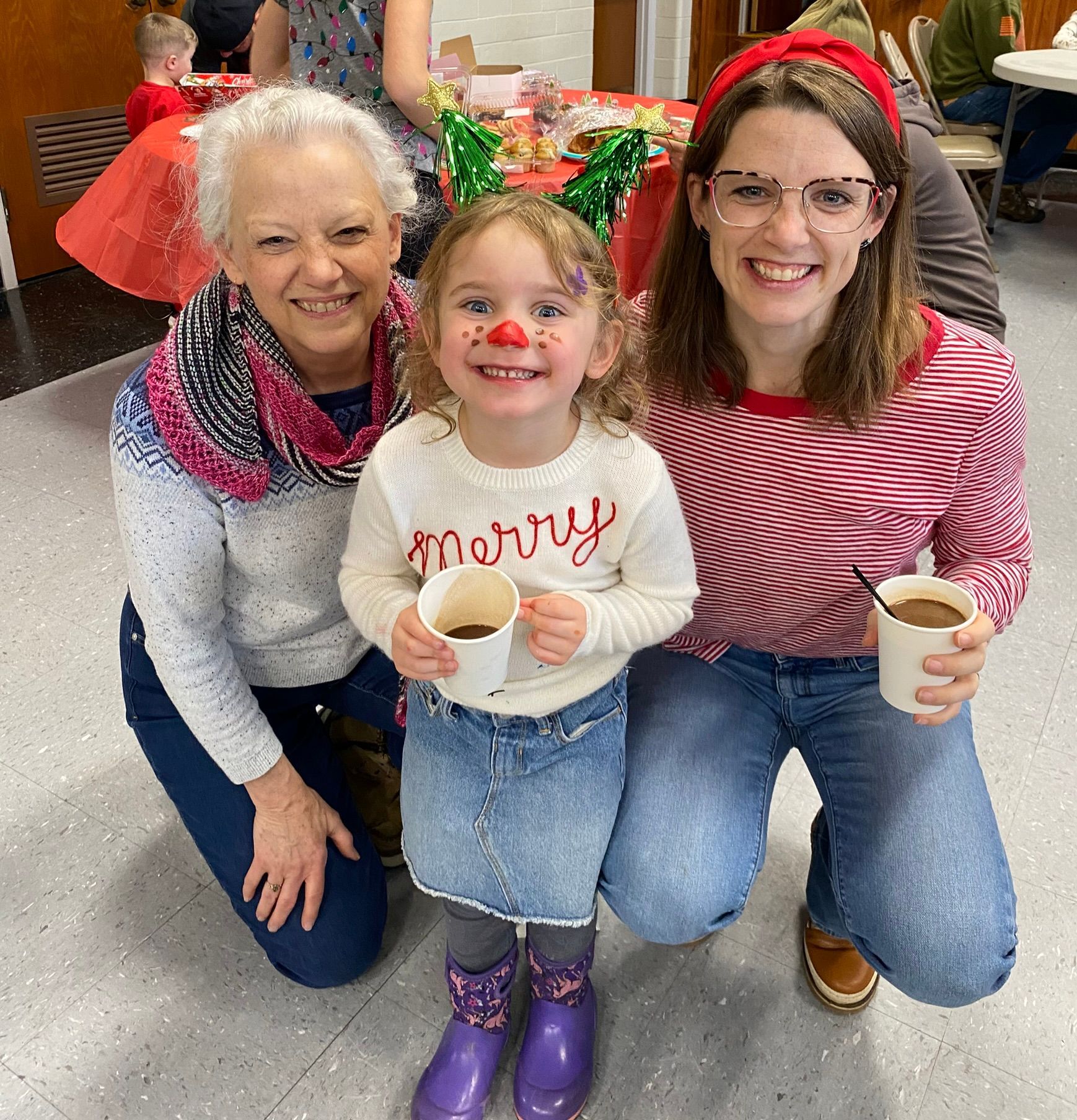 Two women and a little girl are posing for a picture.