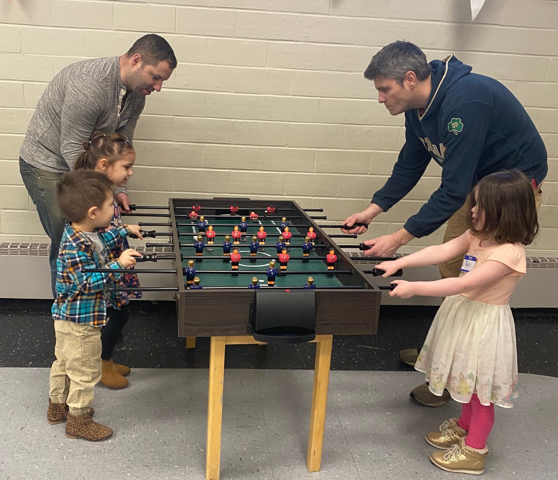 A group of people are playing a game of foosball