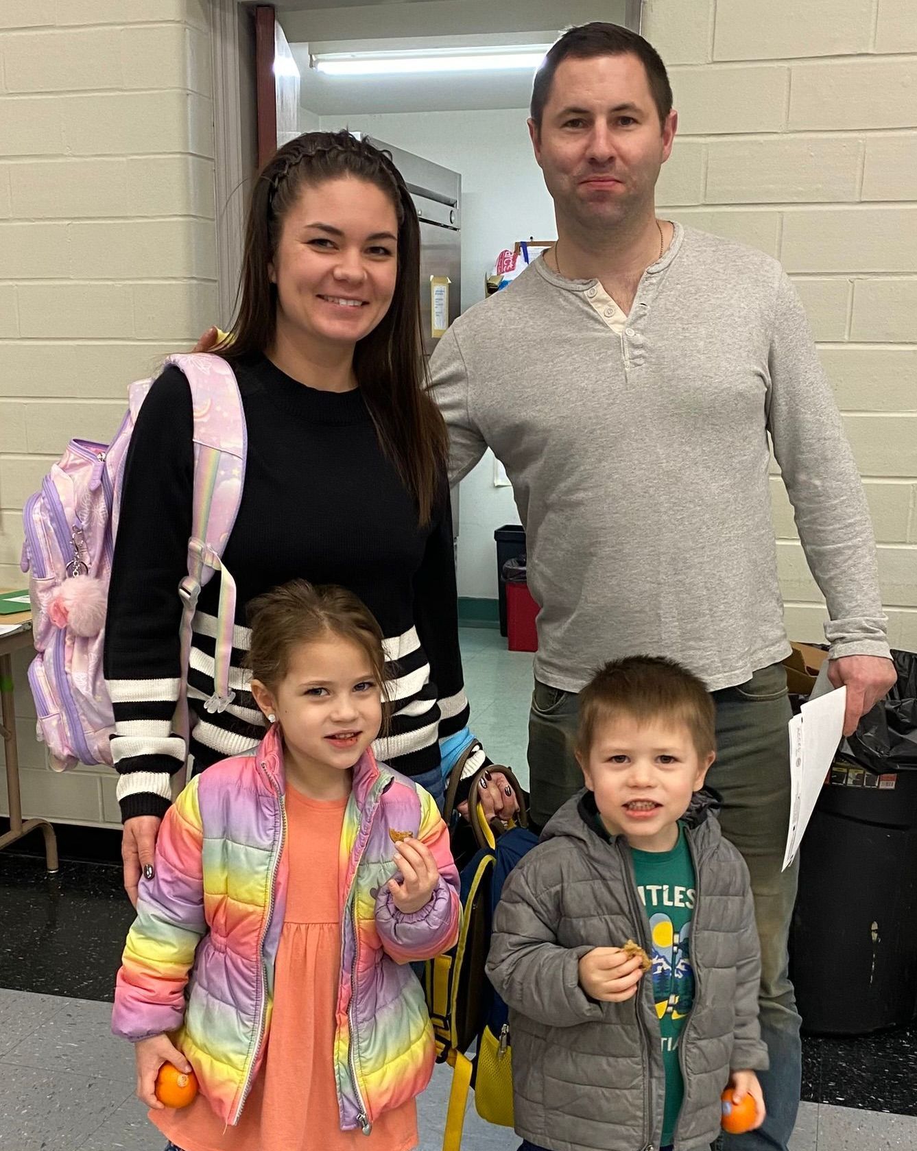 A family is posing for a picture in a hallway.