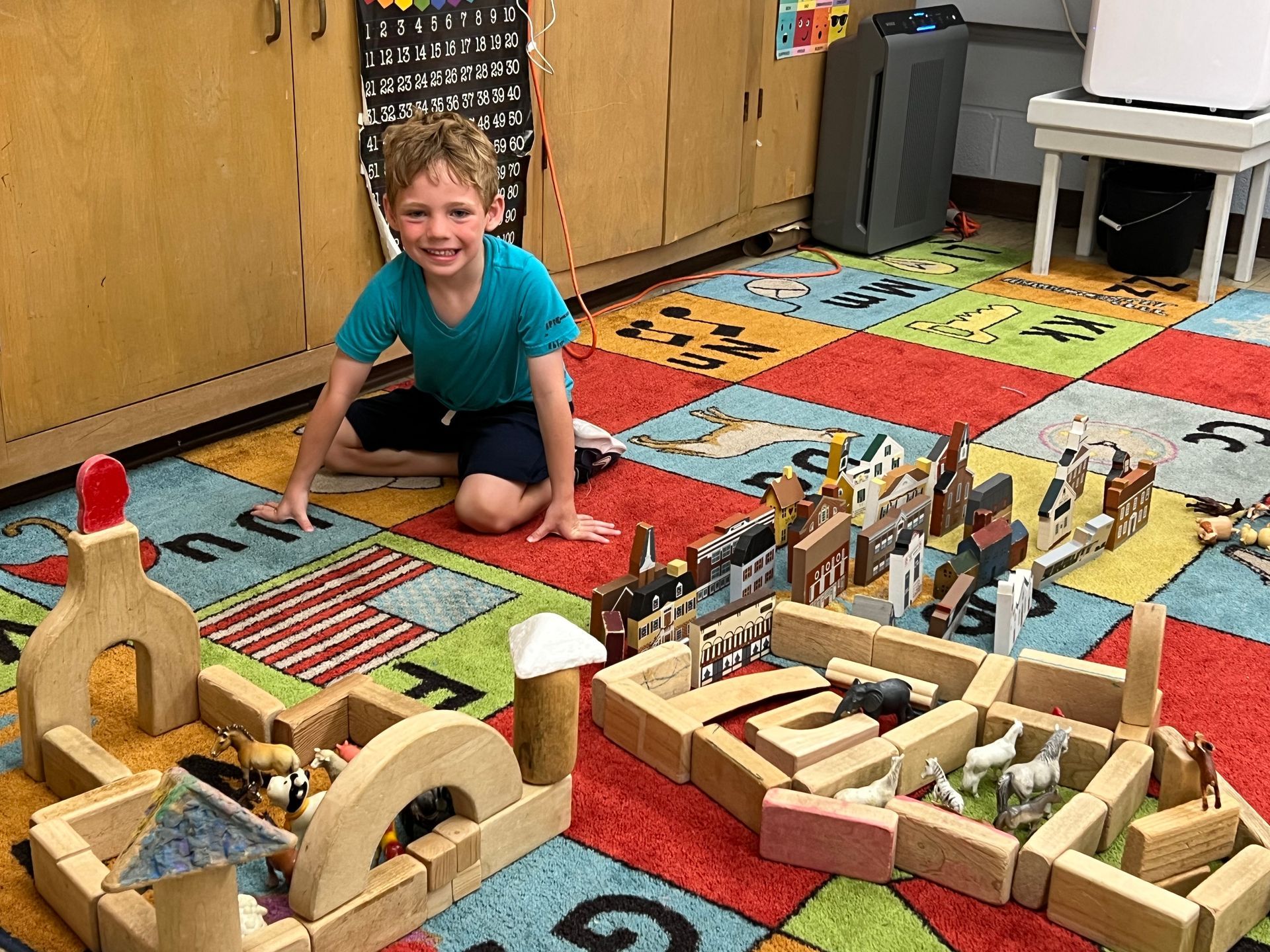 A young boy is sitting on the floor playing with wooden blocks.