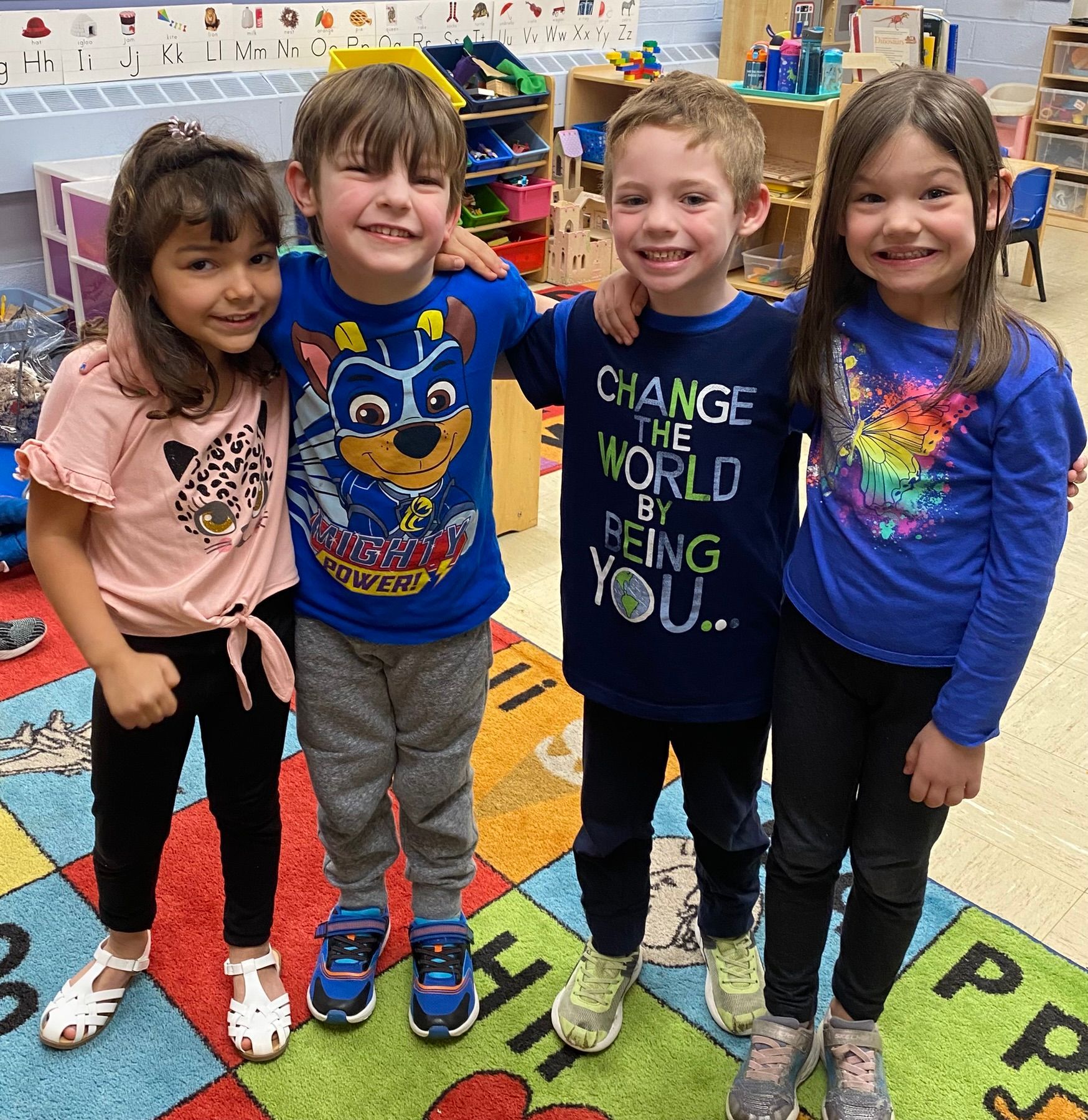 A group of children are posing for a picture in a classroom.