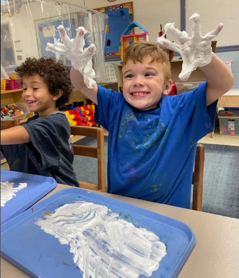 Two young boys are playing with foam in a classroom