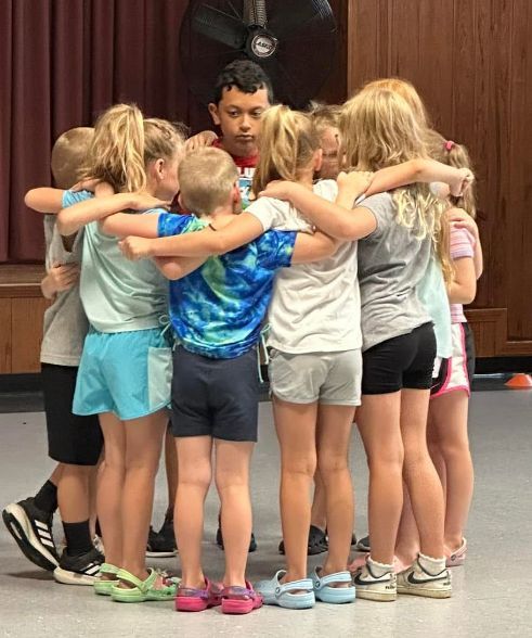 A group of children are hugging each other in a huddle