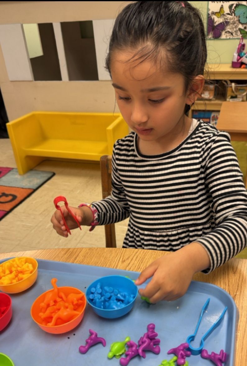 A little girl is playing with toys on a table
