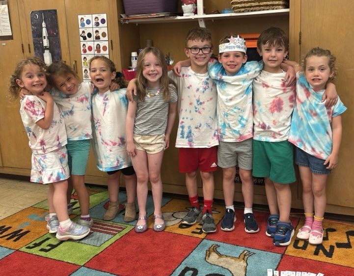 A group of children are posing for a picture in a classroom.