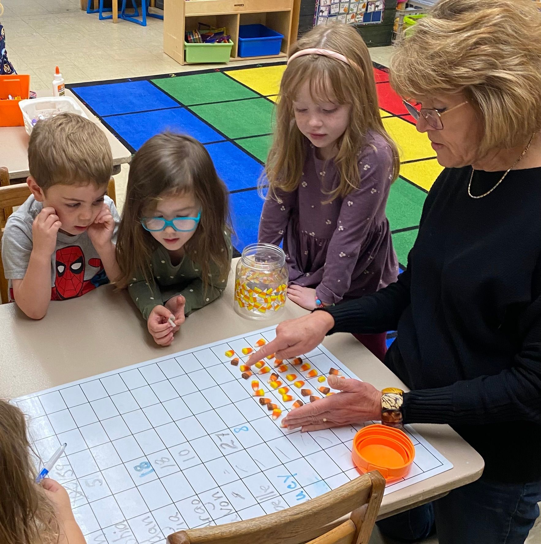 A group of children are sitting around a table playing a game