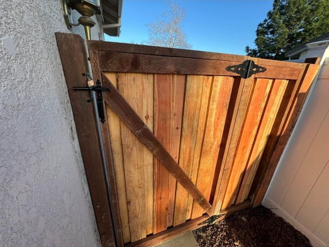 a side gate installed to protect dogs from getting out or people from getting in with a high latch