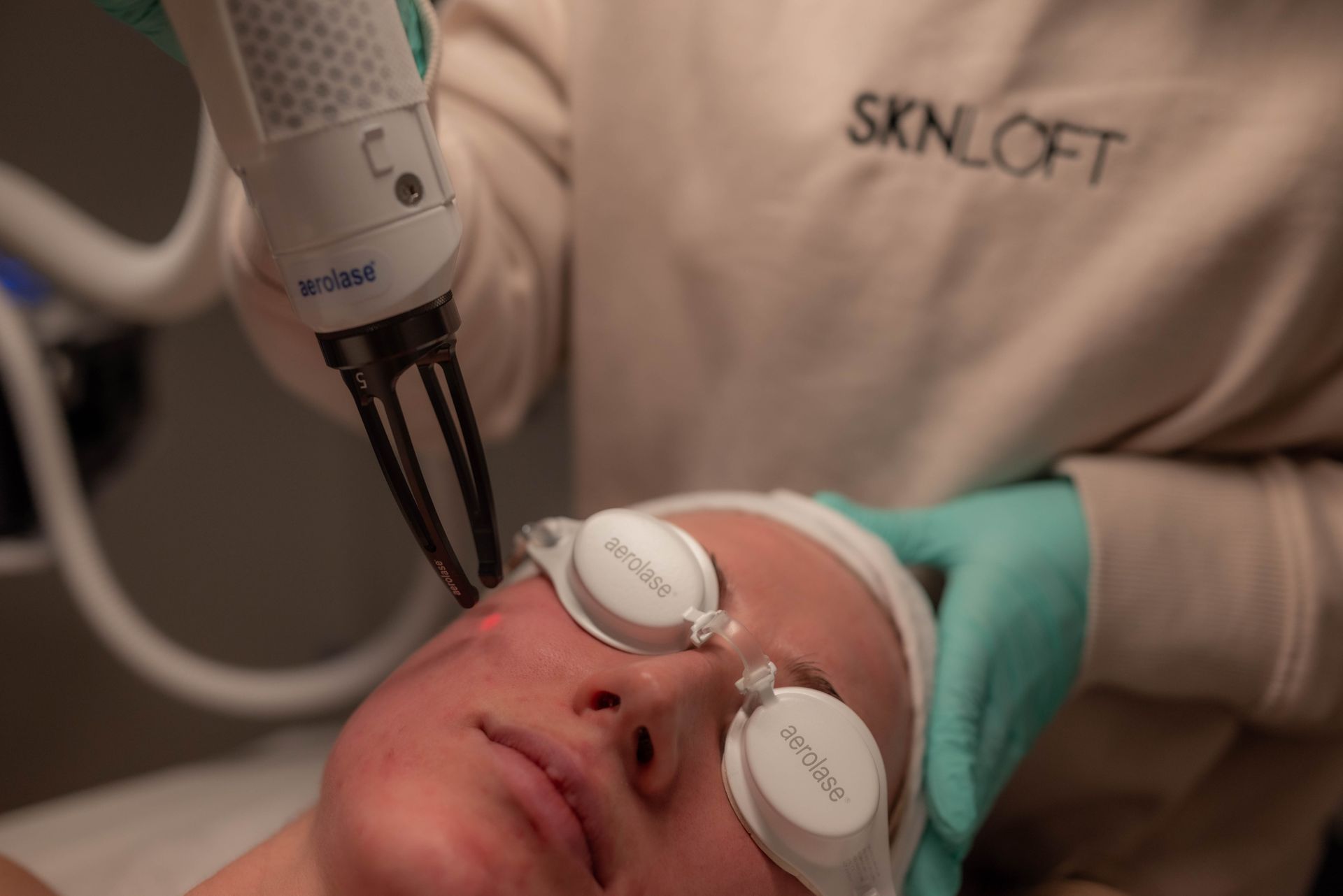 A woman is getting a laser treatment on her face.
