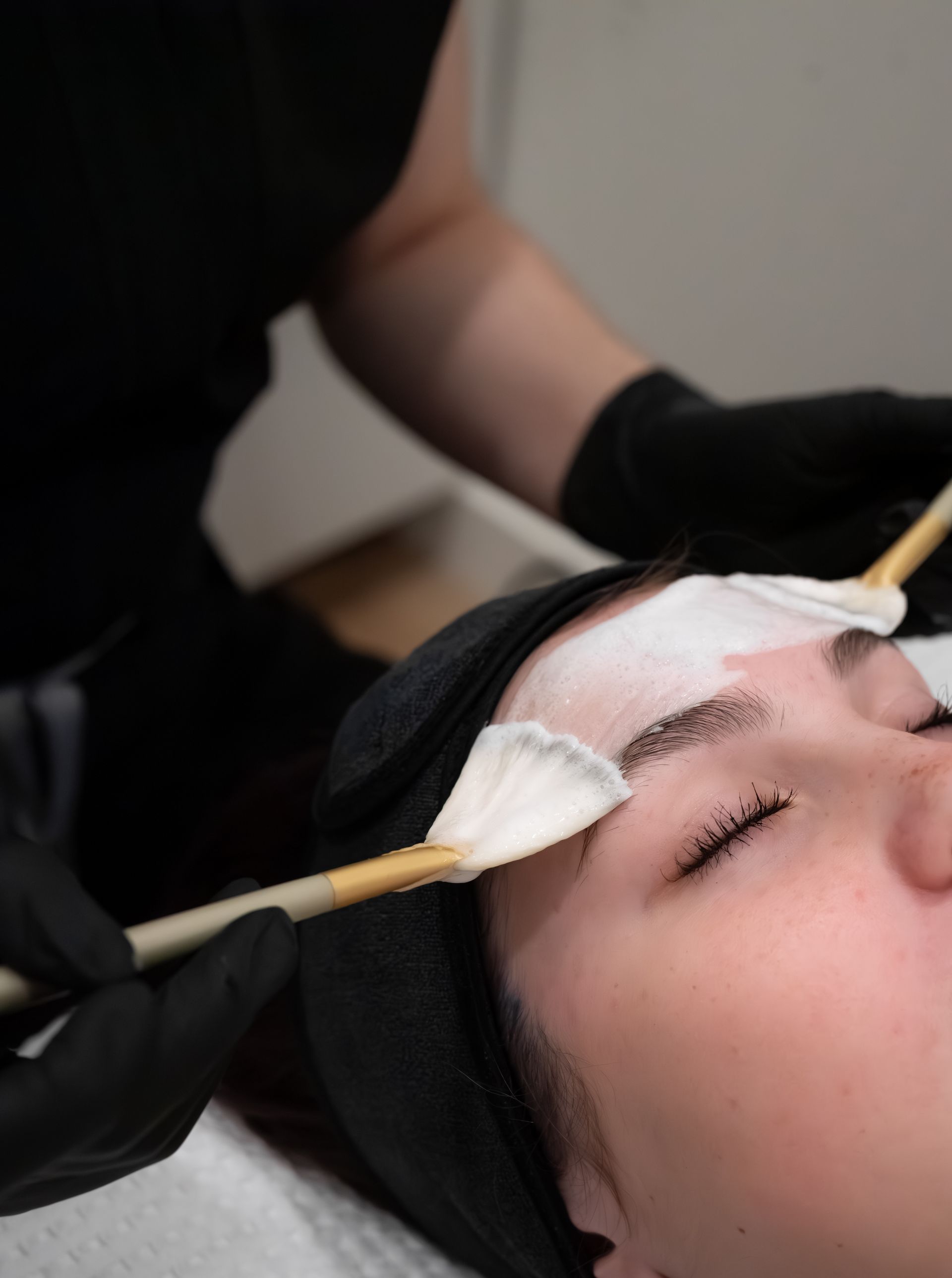 A woman is getting a facial massage at a spa.