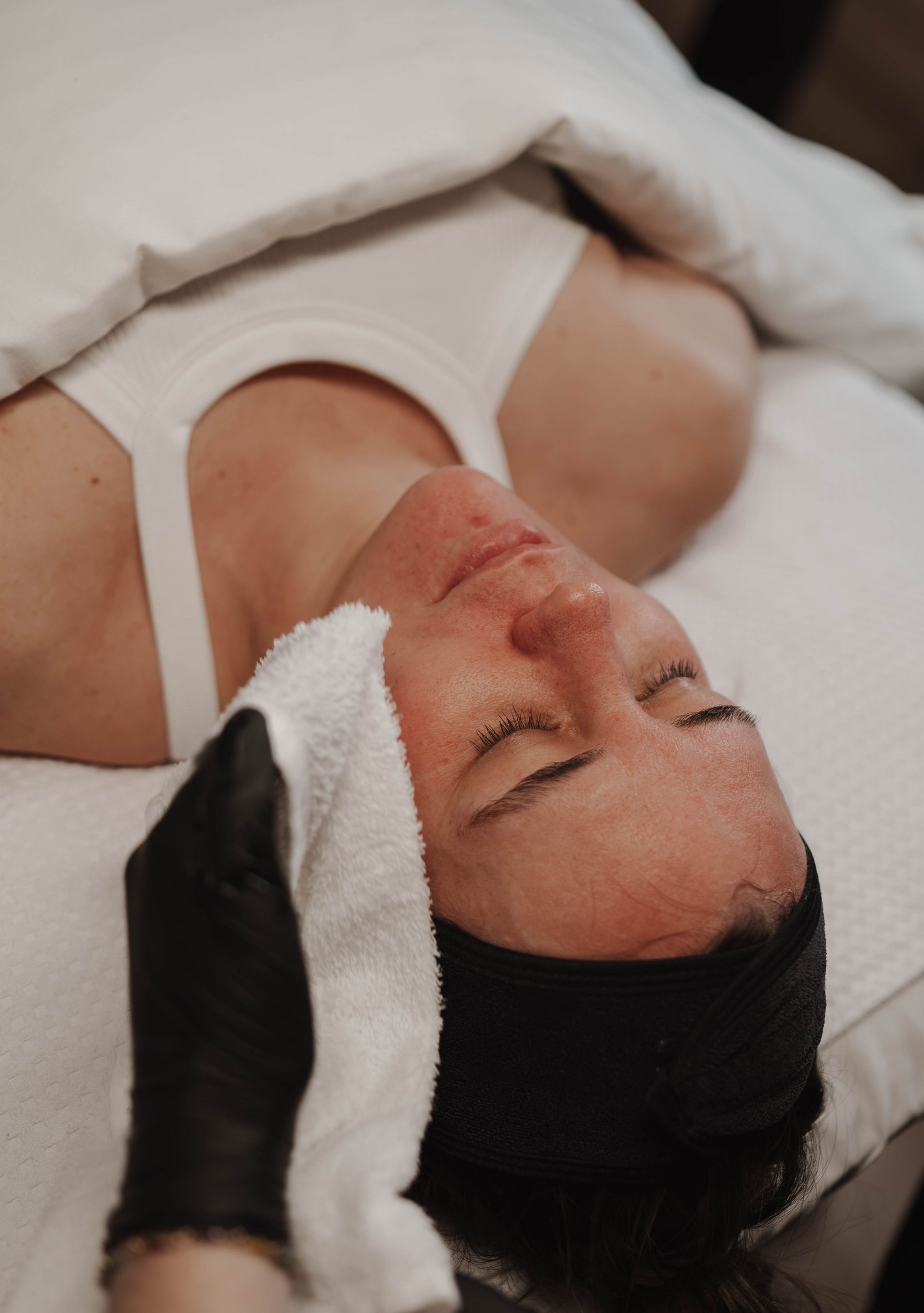 Two women are sitting on a stool in a room talking to each other.