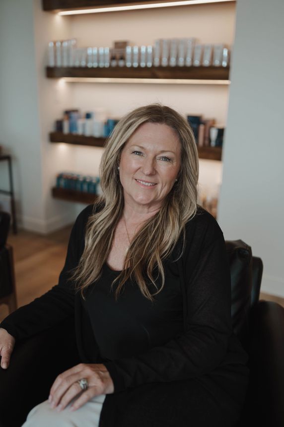 A woman in a black shirt is sitting in a chair