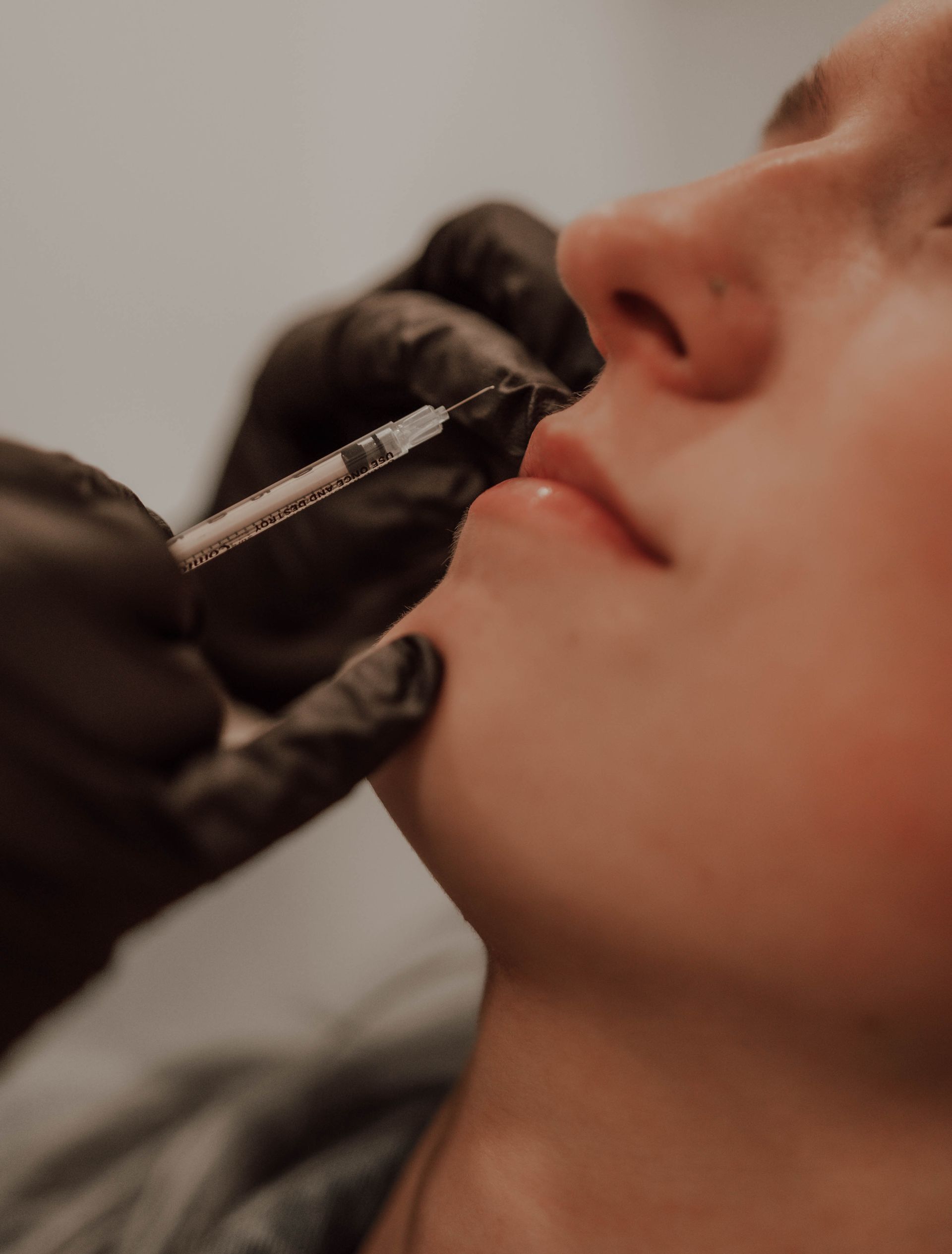 A woman is getting a botox injection in her lip.