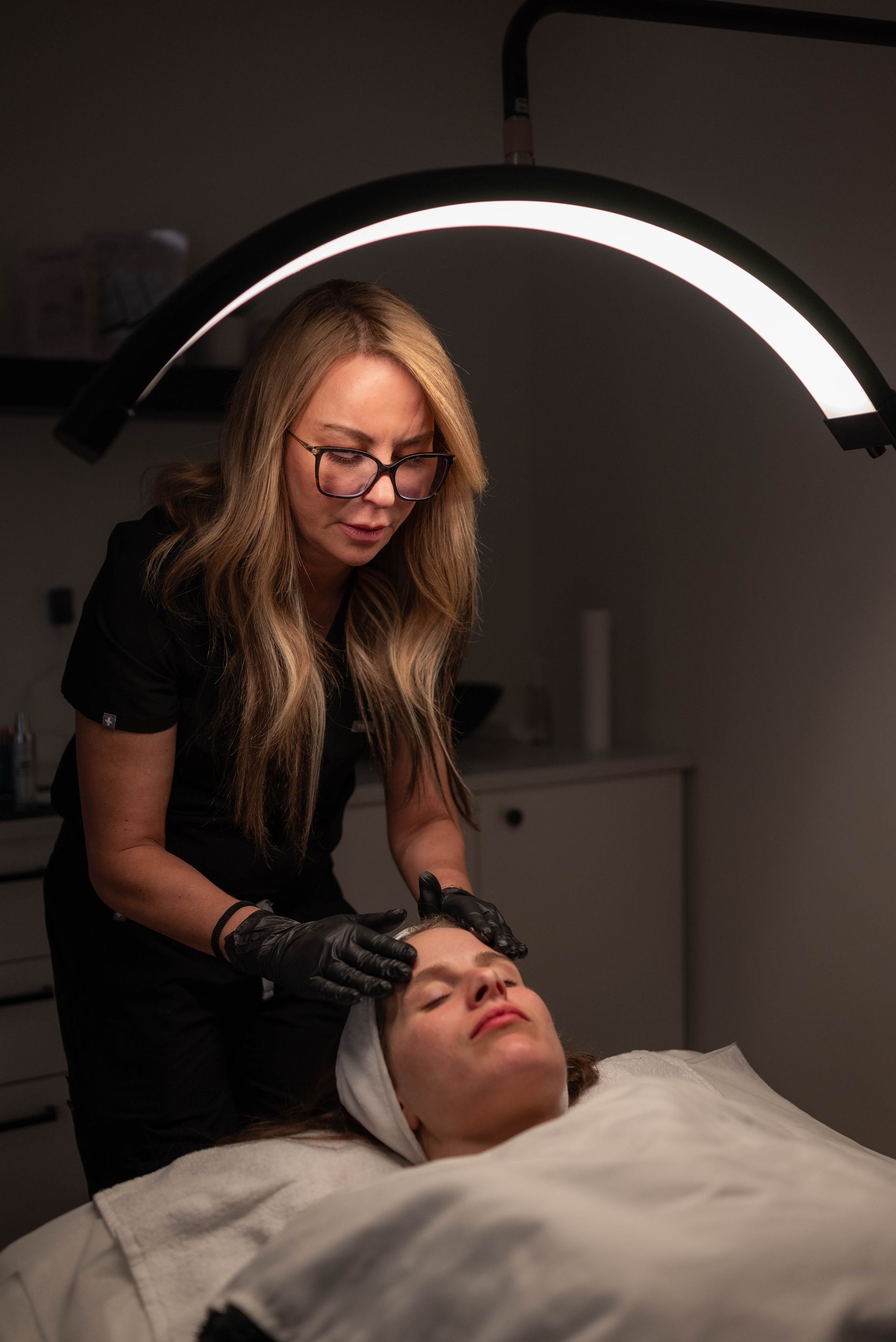 A woman is giving a woman a facial treatment in a beauty salon.