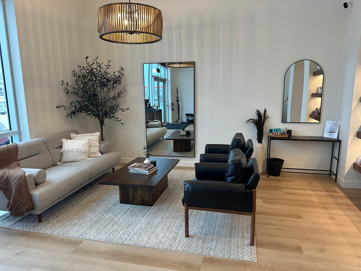 a living room with a couch , chairs , coffee table and mirror .
