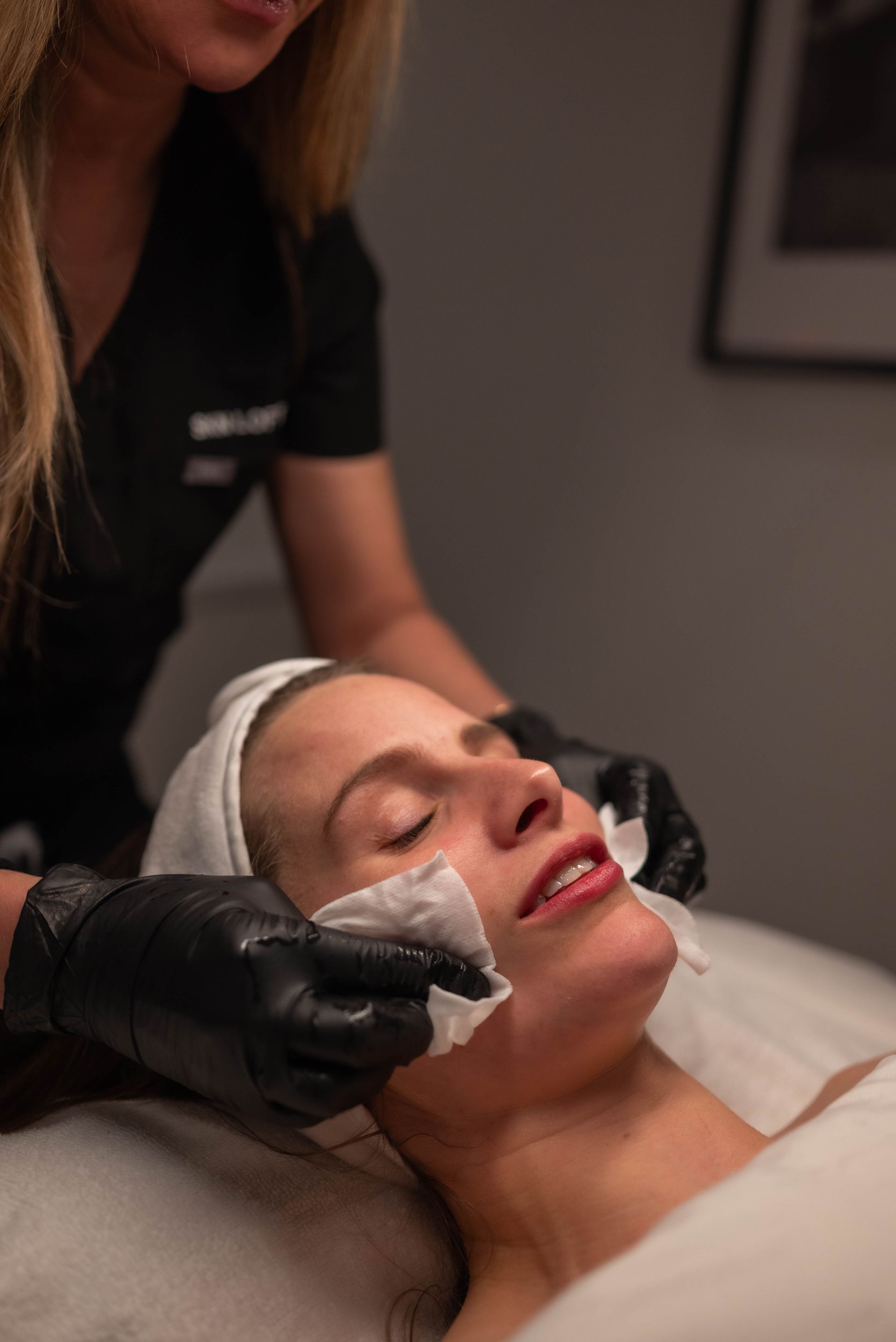 A woman is giving a woman a facial treatment in a beauty salon.