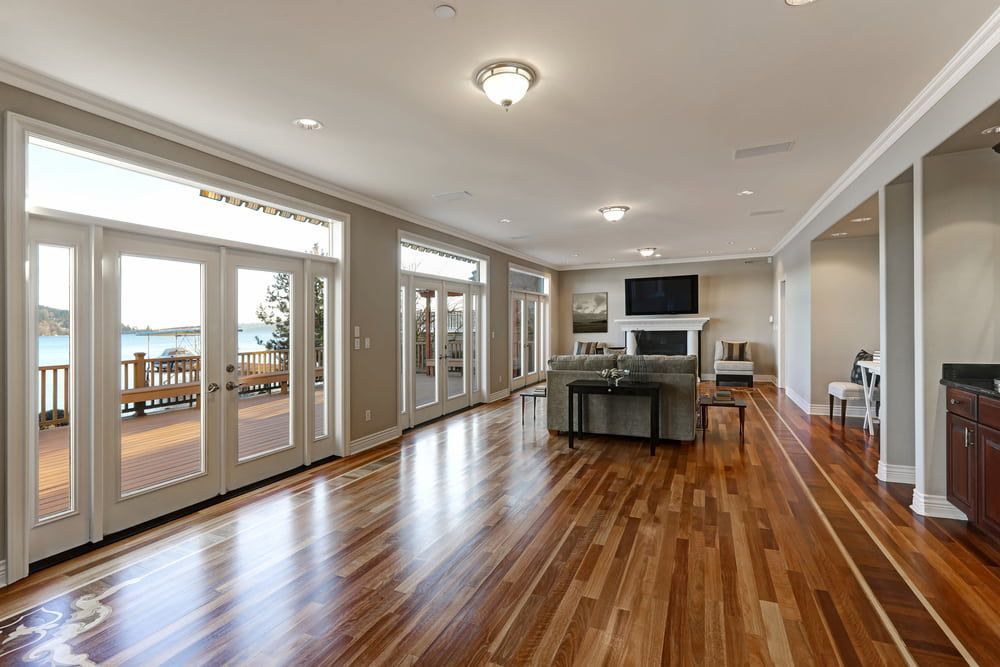 A Living Room with Hardwood Floors and Lots of Windows — Bulli Glass in Shellharbour, NSW