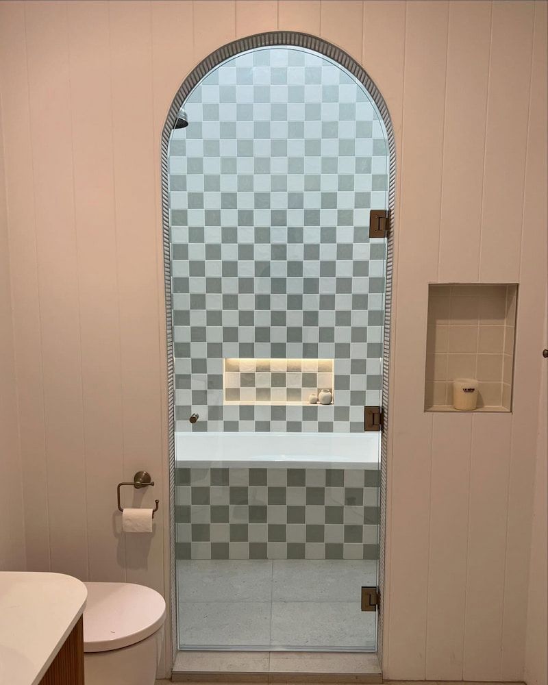 A Bathroom with a Glass Shower Door and a Bathtub — Bulli Glass in Wollongong, NSW
