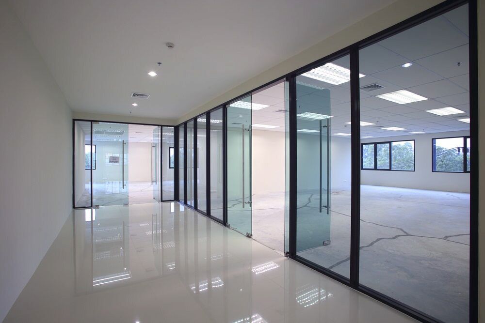 An Empty Office Building with a Lot of Windows and Sliding Glass Doors — Bulli Glass in Dapto, NSW