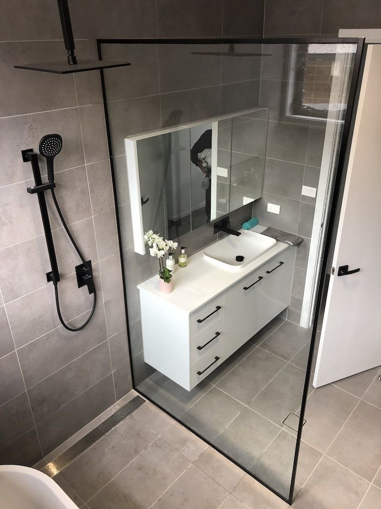 A Bathroom with a Sink, Mirror and Shower — Bulli Glass in Dapto, NSW
