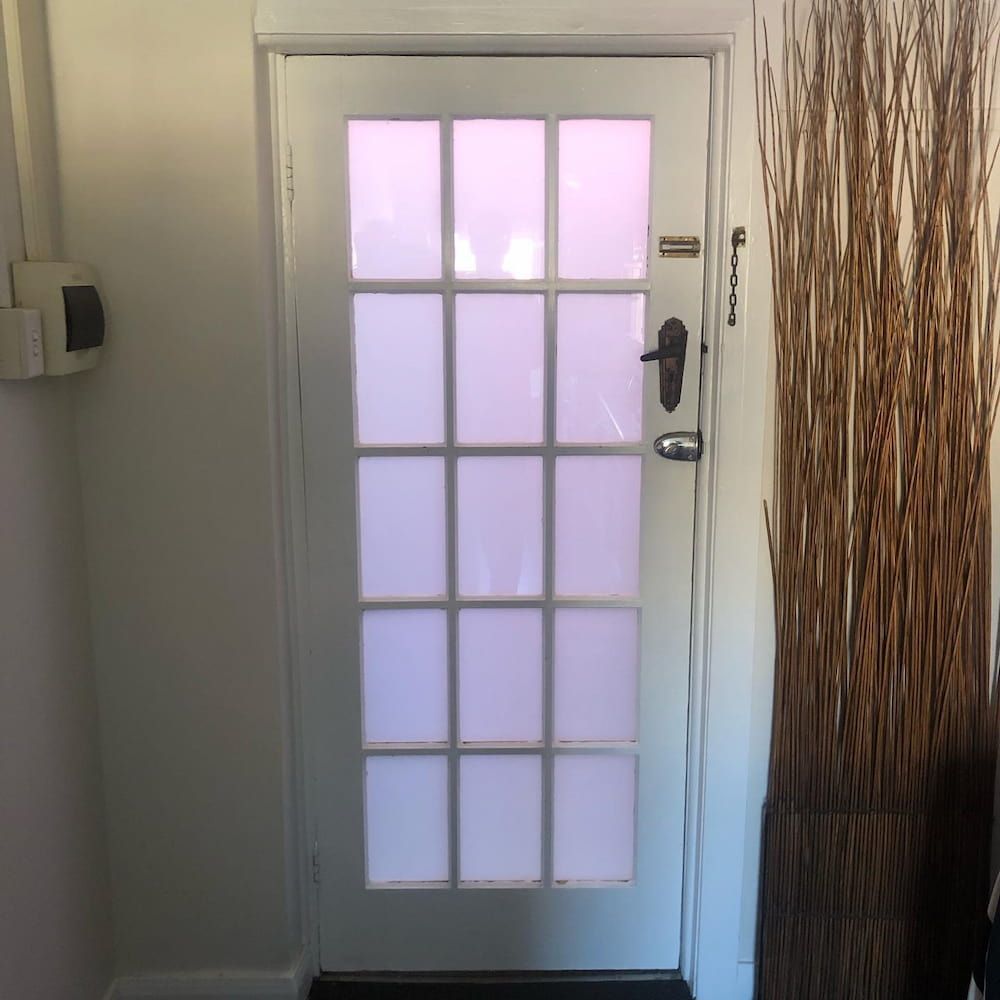 A White Door with a Pink Light Behind It in a Room — Bulli Glass in Albion Park, NSW