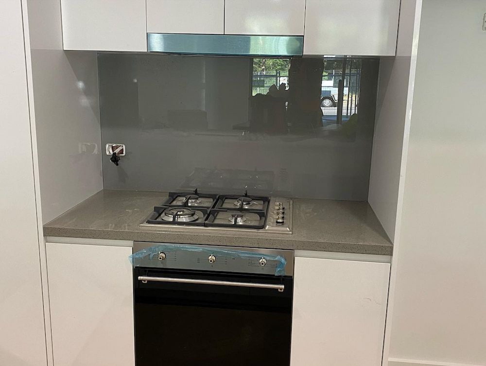 A Kitchen with a Stove Top Oven and a Hood — Bulli Glass in Bulli, NSW