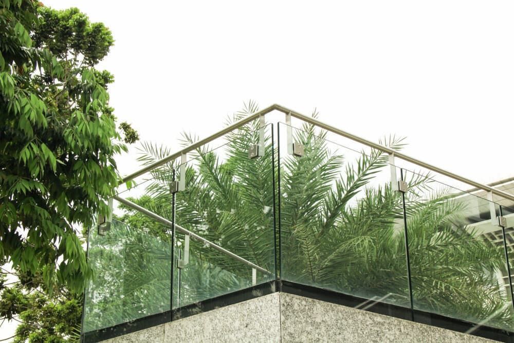 A Balcony with a Glass Railing and Trees in the Background — Bulli Glass in Bulli, NSW