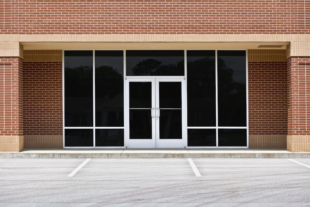 A Brick Building with a Parking Lot in Front of It — Bulli Glass in Bulli, NSW