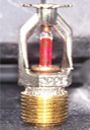 Fire sprinkler head with brass base and red glass bulb.