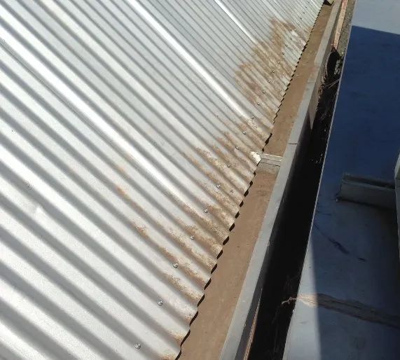 A close up of a gutter on a metal roof