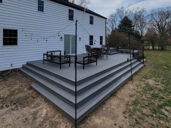 Carpenter using a yellow drill to attach wood to a wooden shelf in a workshop.
