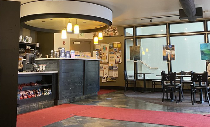 A restaurant with tables and chairs and a counter