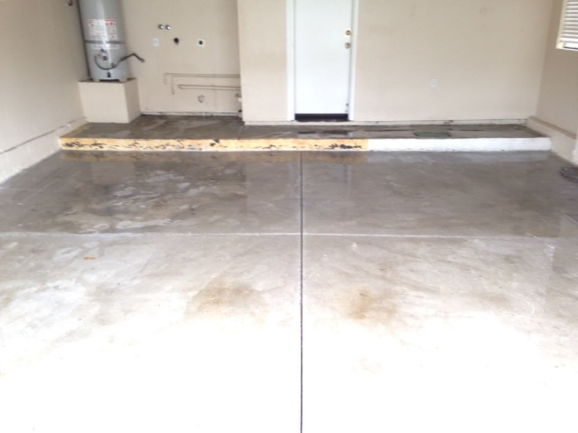 A garage with a concrete floor and a white door