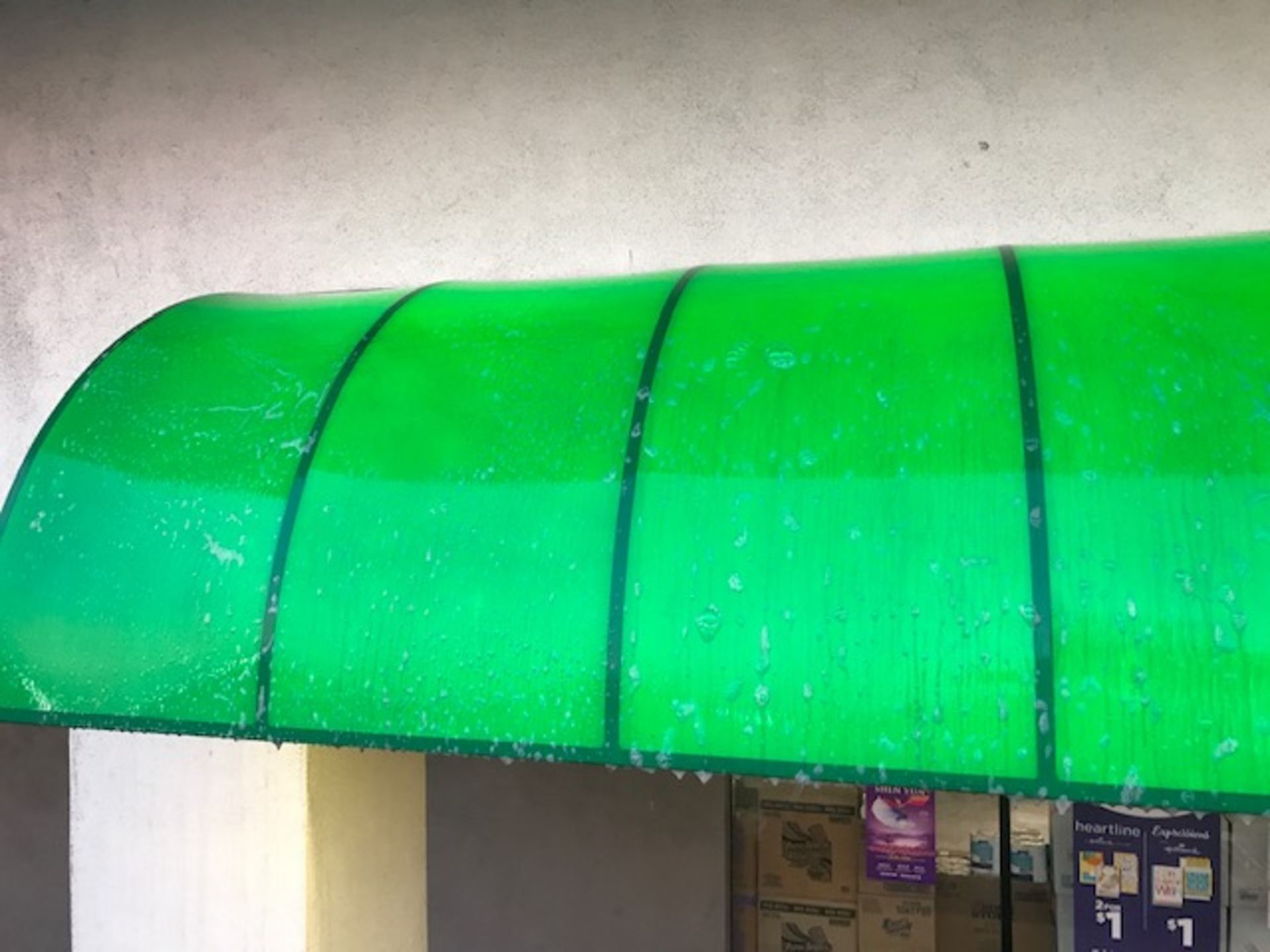 A green awning is sitting on top of a building.