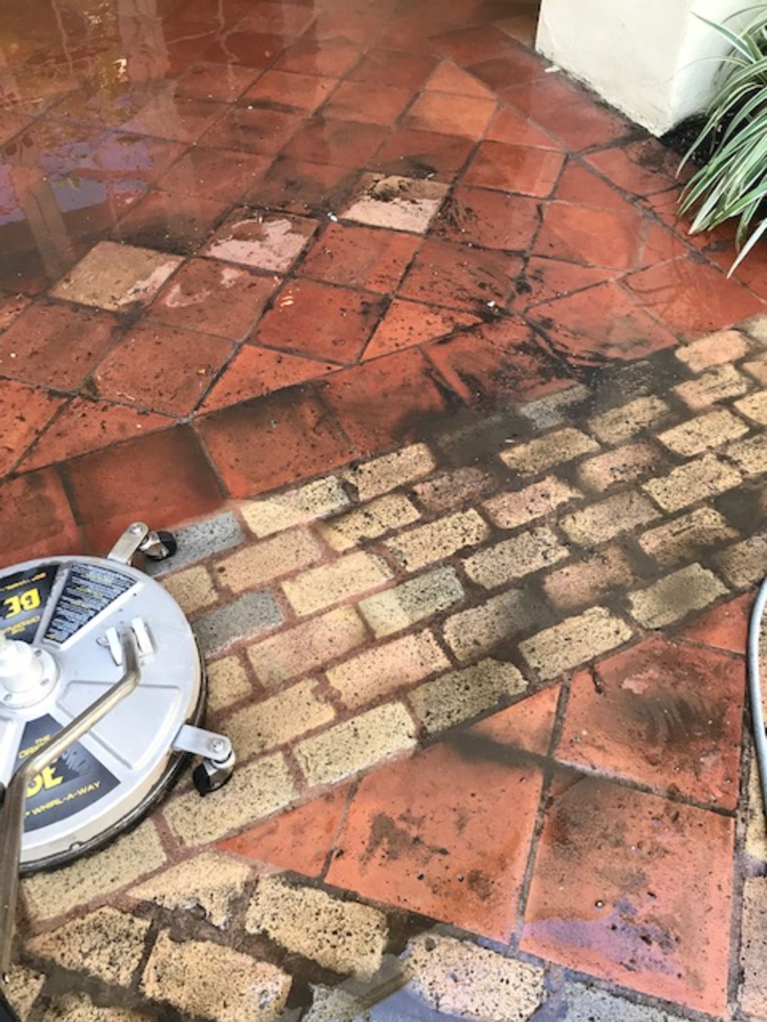 A person is cleaning a brick floor with a machine.