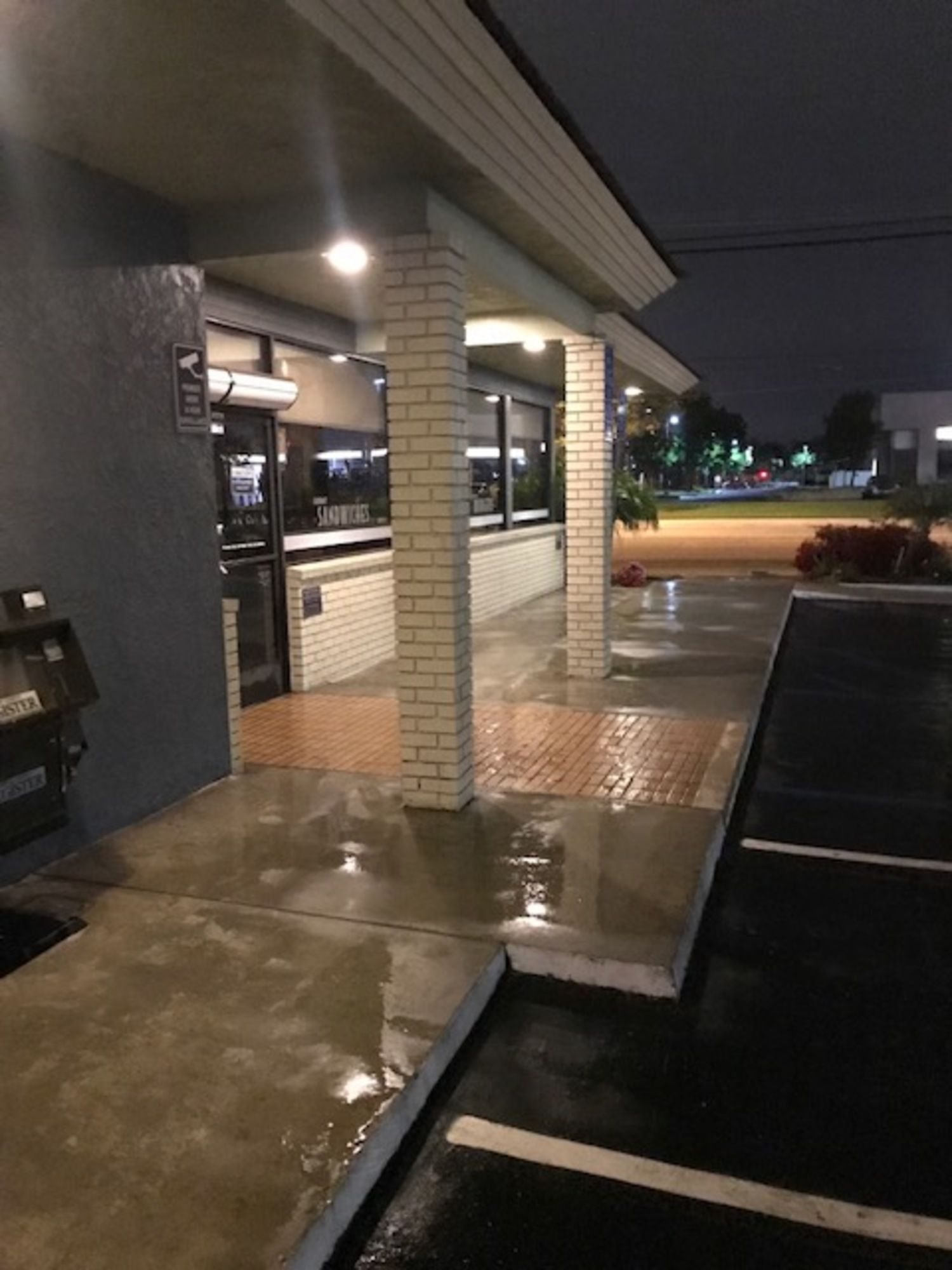A brick building with a parking lot in front of it