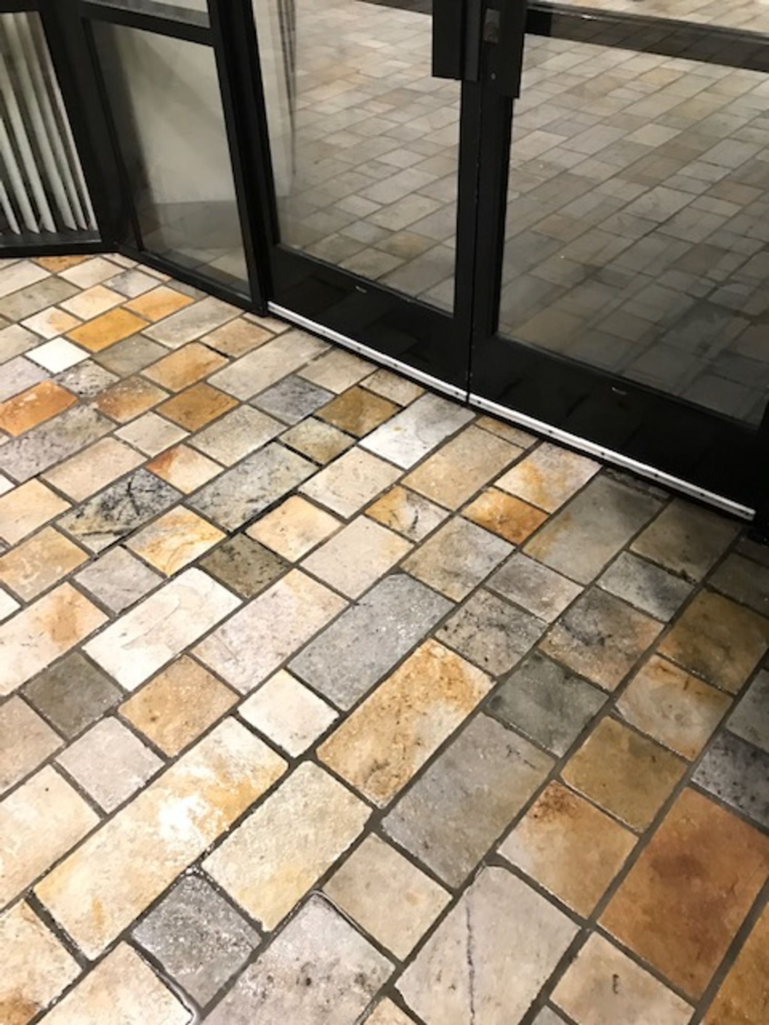 A close up of a tiled floor next to a glass door.