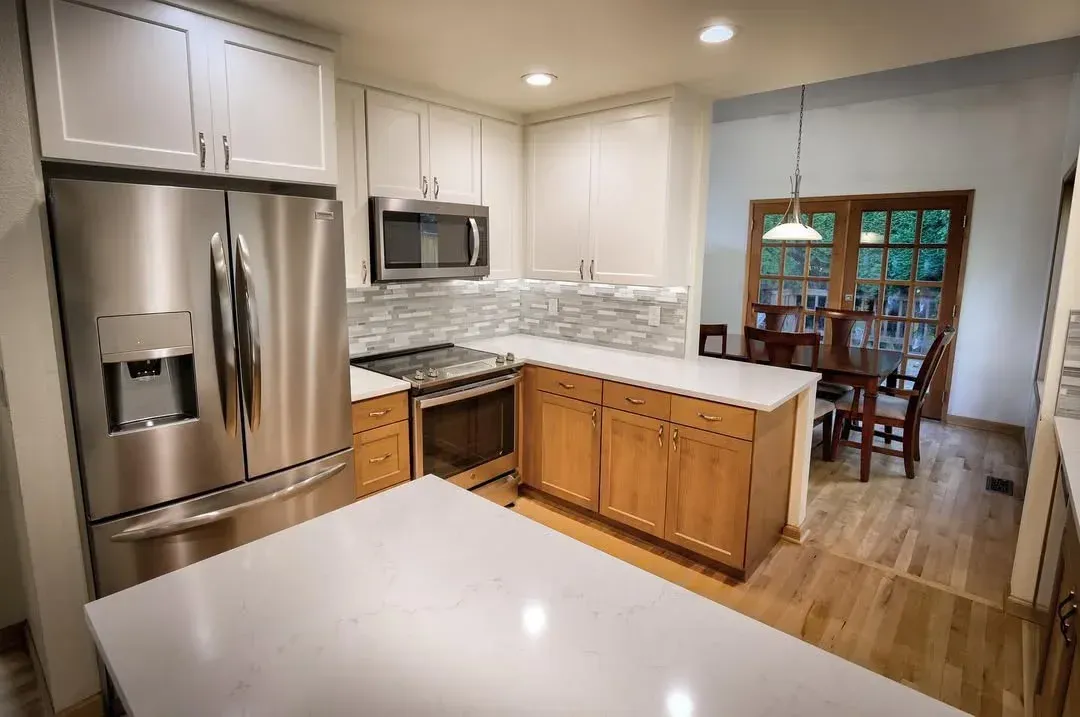 Bright modern kitchen with white cabinets, island, farmhouse sink, and stainless steel appliances