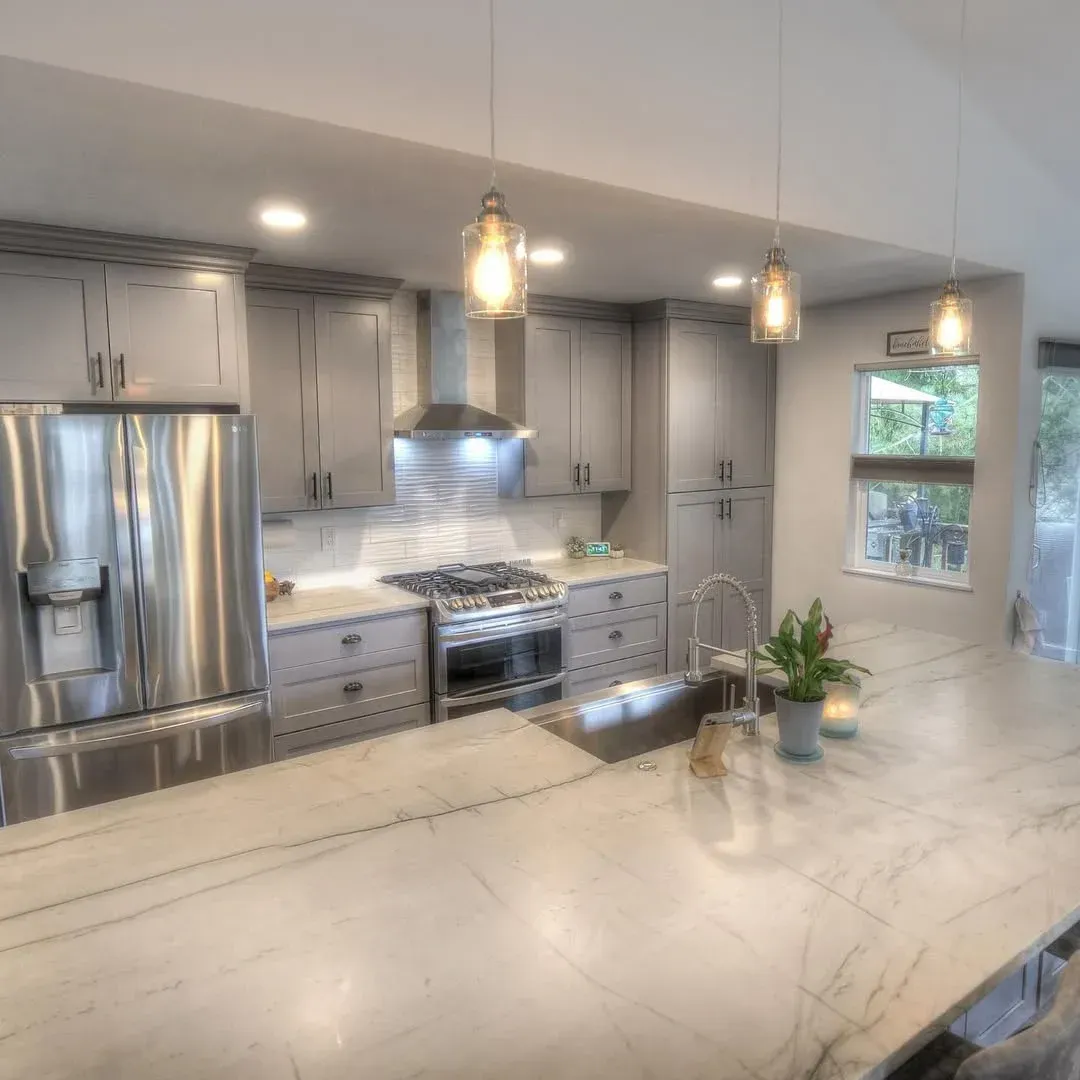 Bright modern kitchen with white cabinets, island, farmhouse sink, and stainless steel appliances