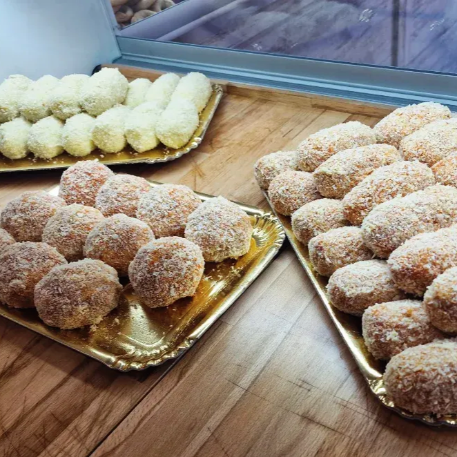 Vassoi di cibo impanato e fritto: crocchette e palline su vassoi dorati.