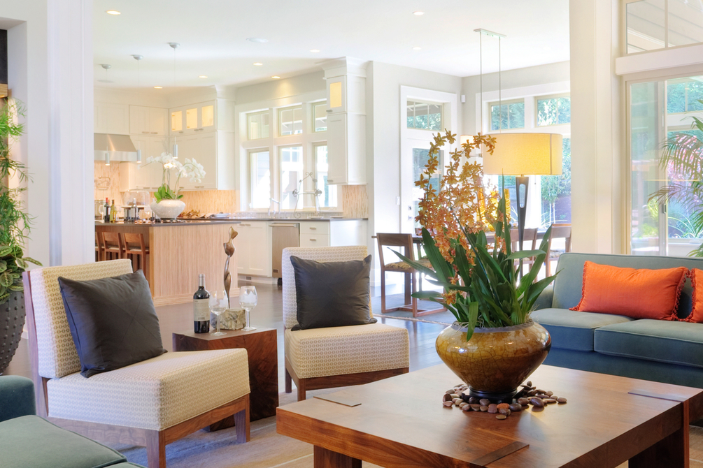 A living room with a couch , chair , coffee table and kitchen.