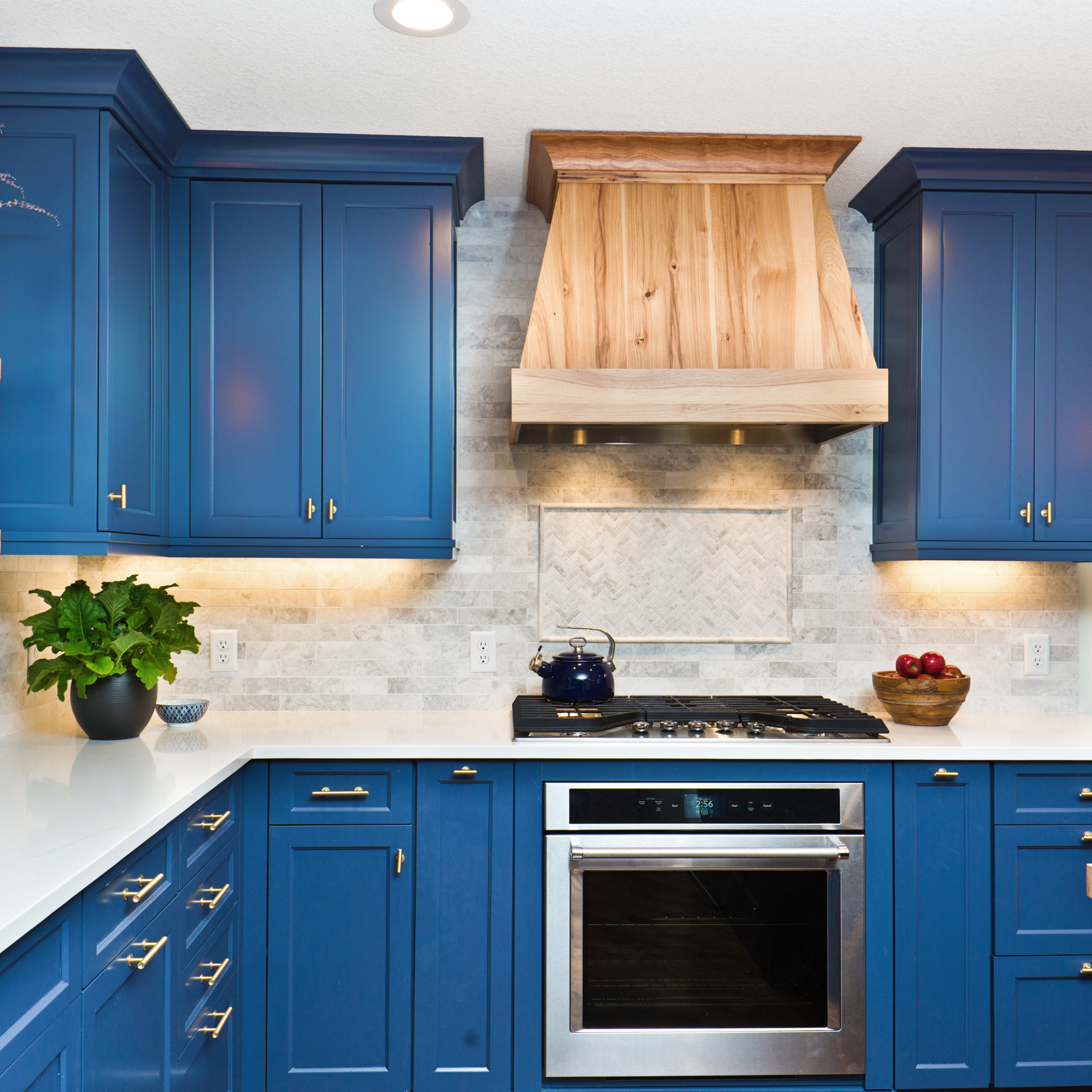A kitchen with blue cabinets and a stove top oven